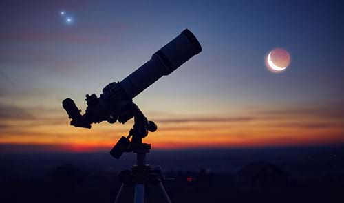 Silueta d'un telescopi d'astronomia amb cel crepuscular © m-gucci / iStock